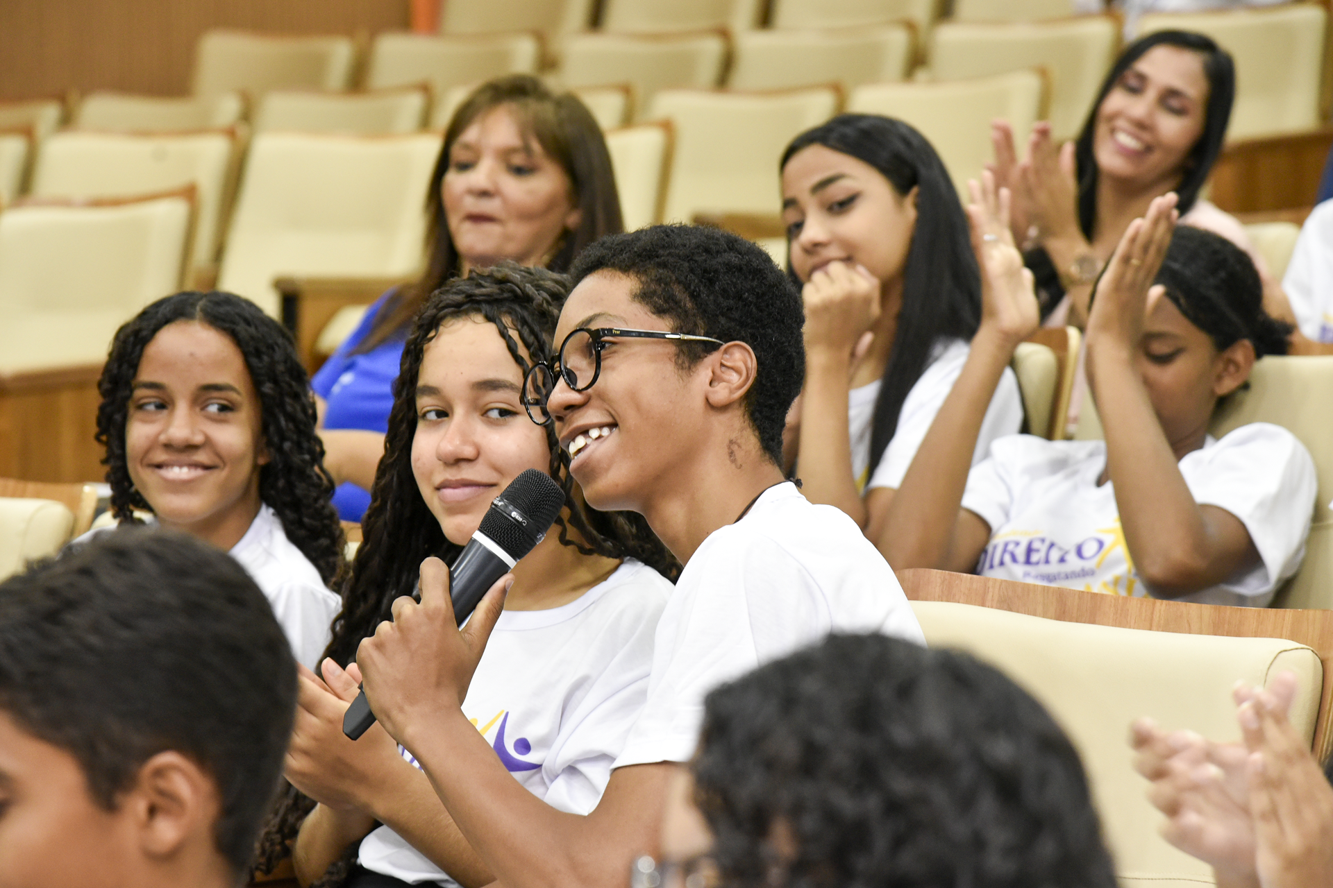 Estudante faz pergunta, durante palestra